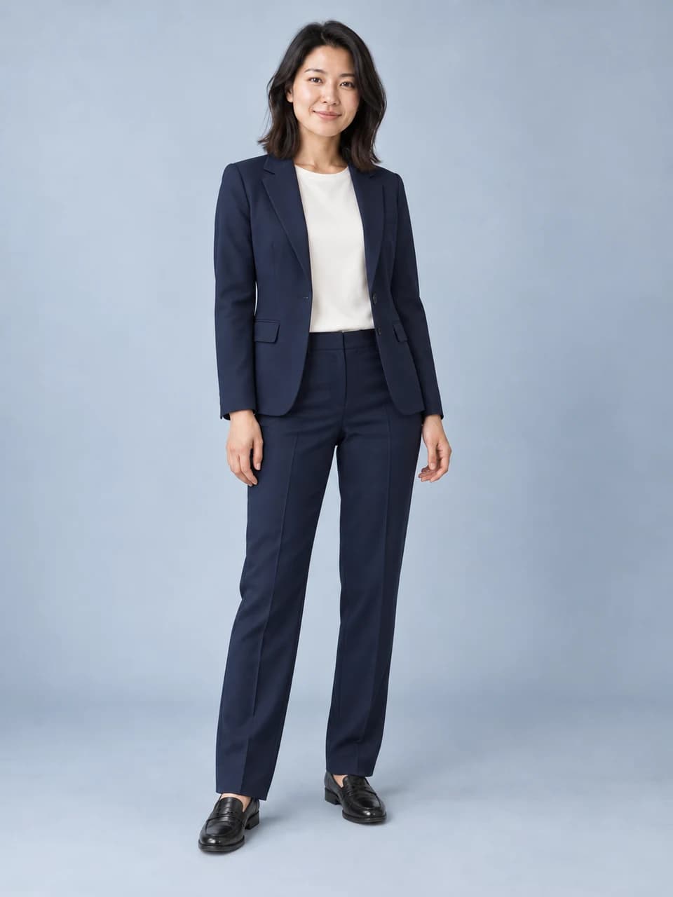 Woman wearing a navy tailored suit in a studio