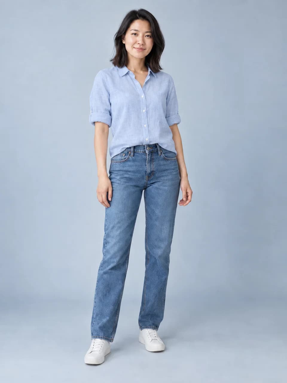 The same woman in a pale-blue linen shirt with the same jeans