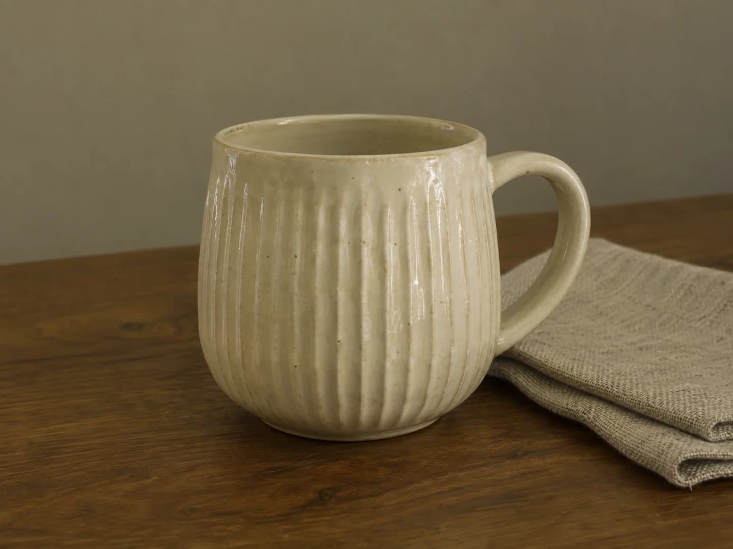 Ivory ribbed ceramic cup with a yellow-green color cast