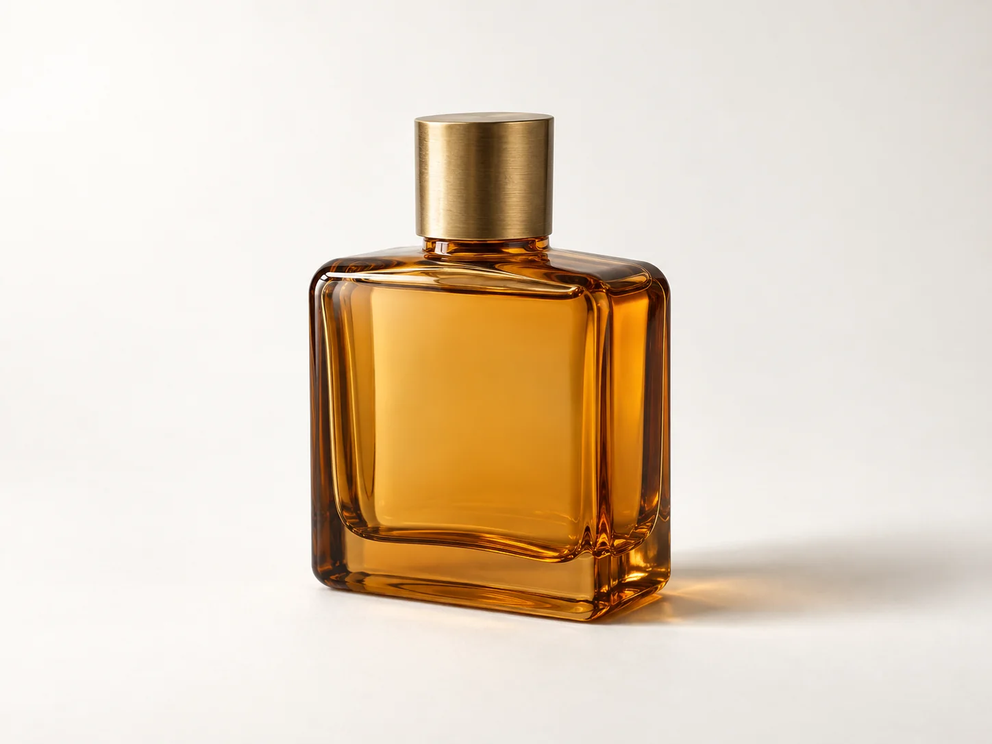 Unbranded amber glass perfume bottle on a warm white studio background