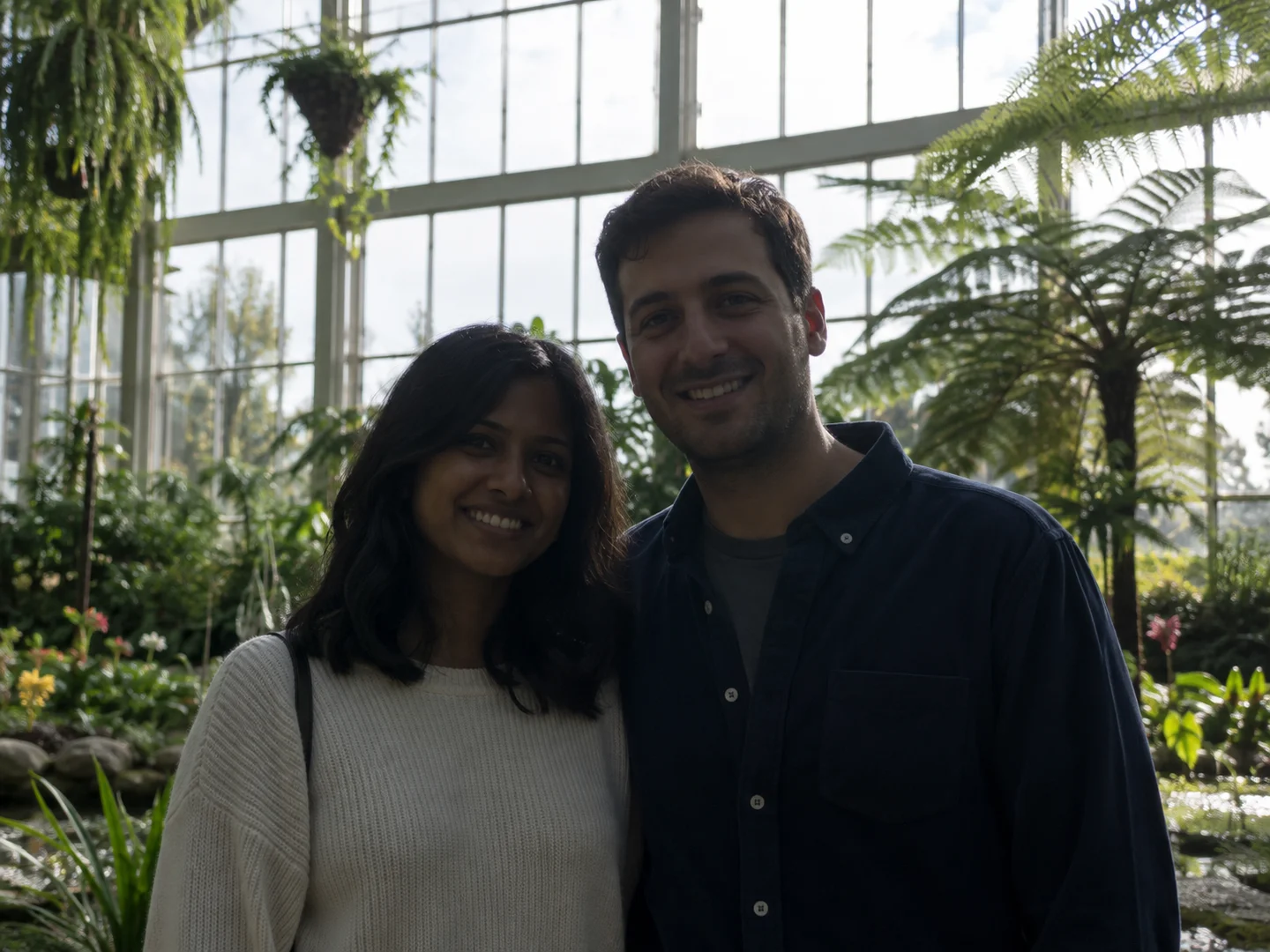 Couple in a greenhouse with their faces underexposed against bright windows