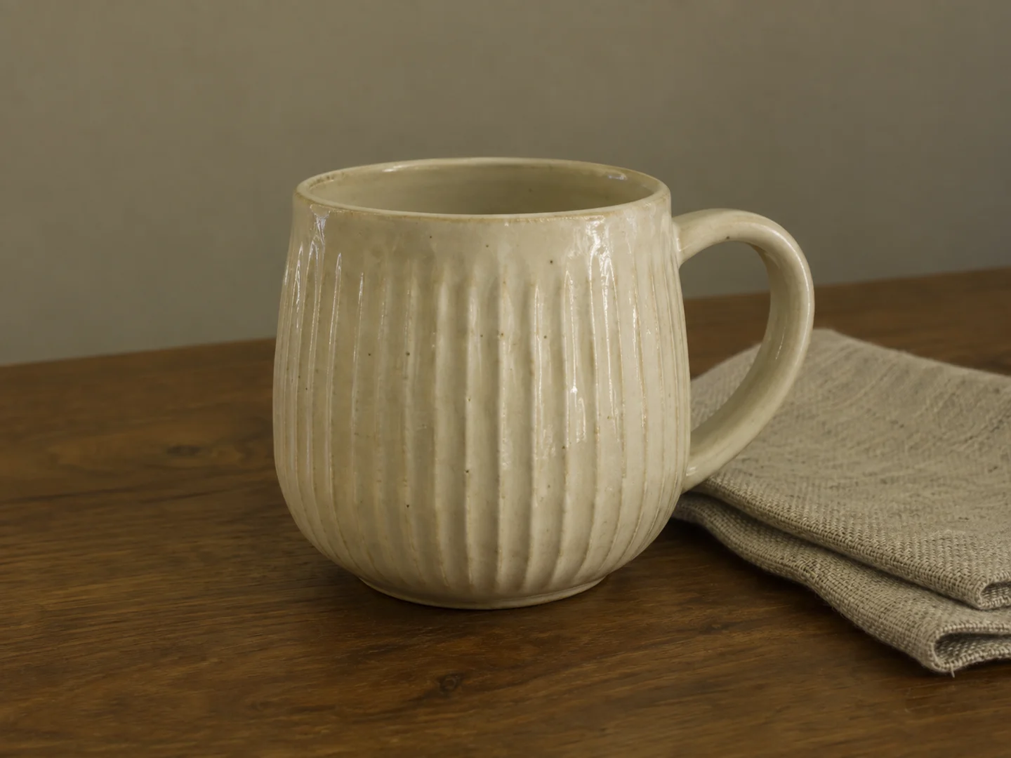 Ivory ribbed ceramic cup with a yellow-green color cast