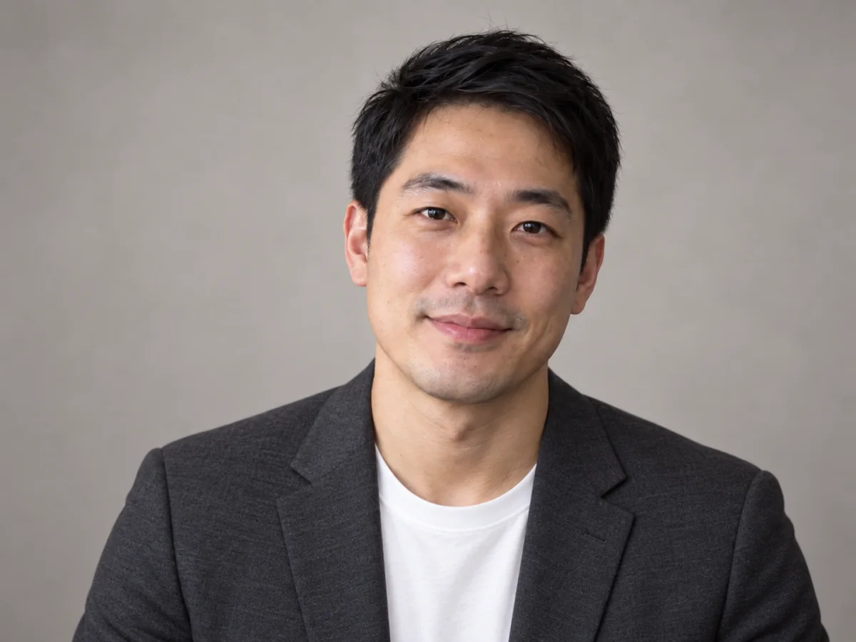 Professional portrait of a man against a warm grey background